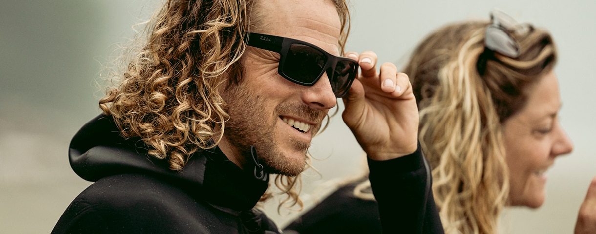 a man in a wetsuit wearing Zeal sunglasses