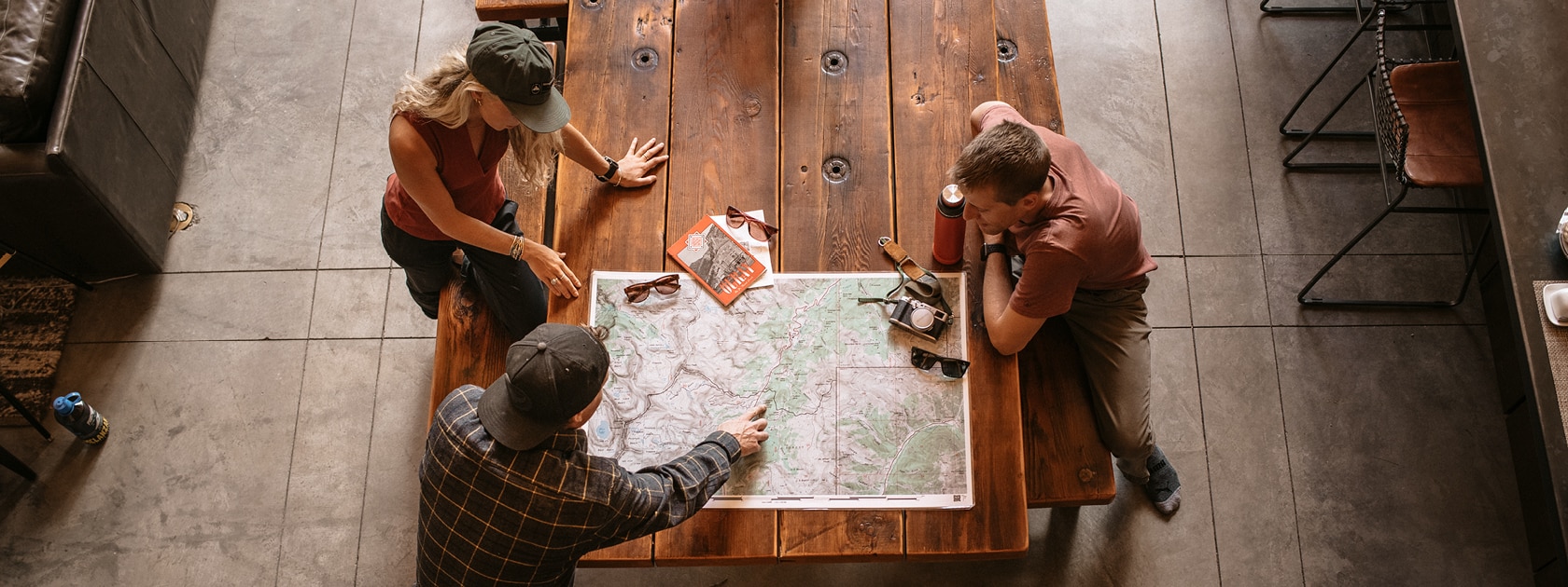 Overhead image of two men and a woman looking at a map on a table