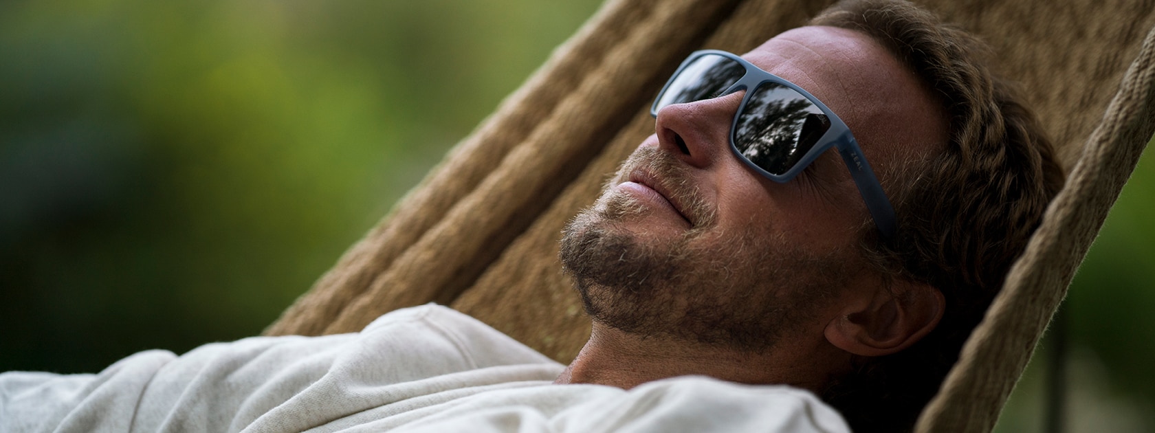 man wearing zeal cam lightweight polarized sunglasses reclining in a hammock