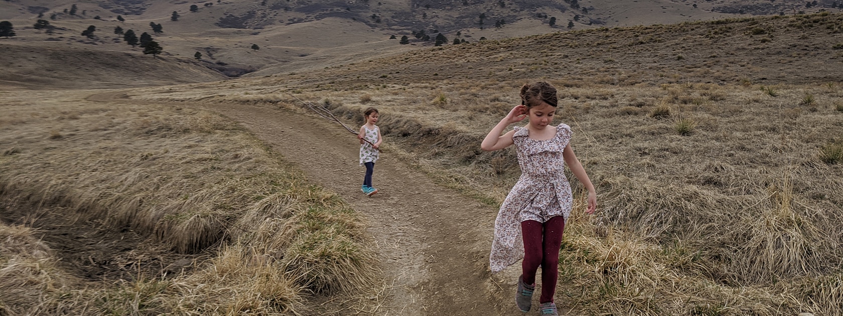 two little girls walk along a trail in the Colorado foothills