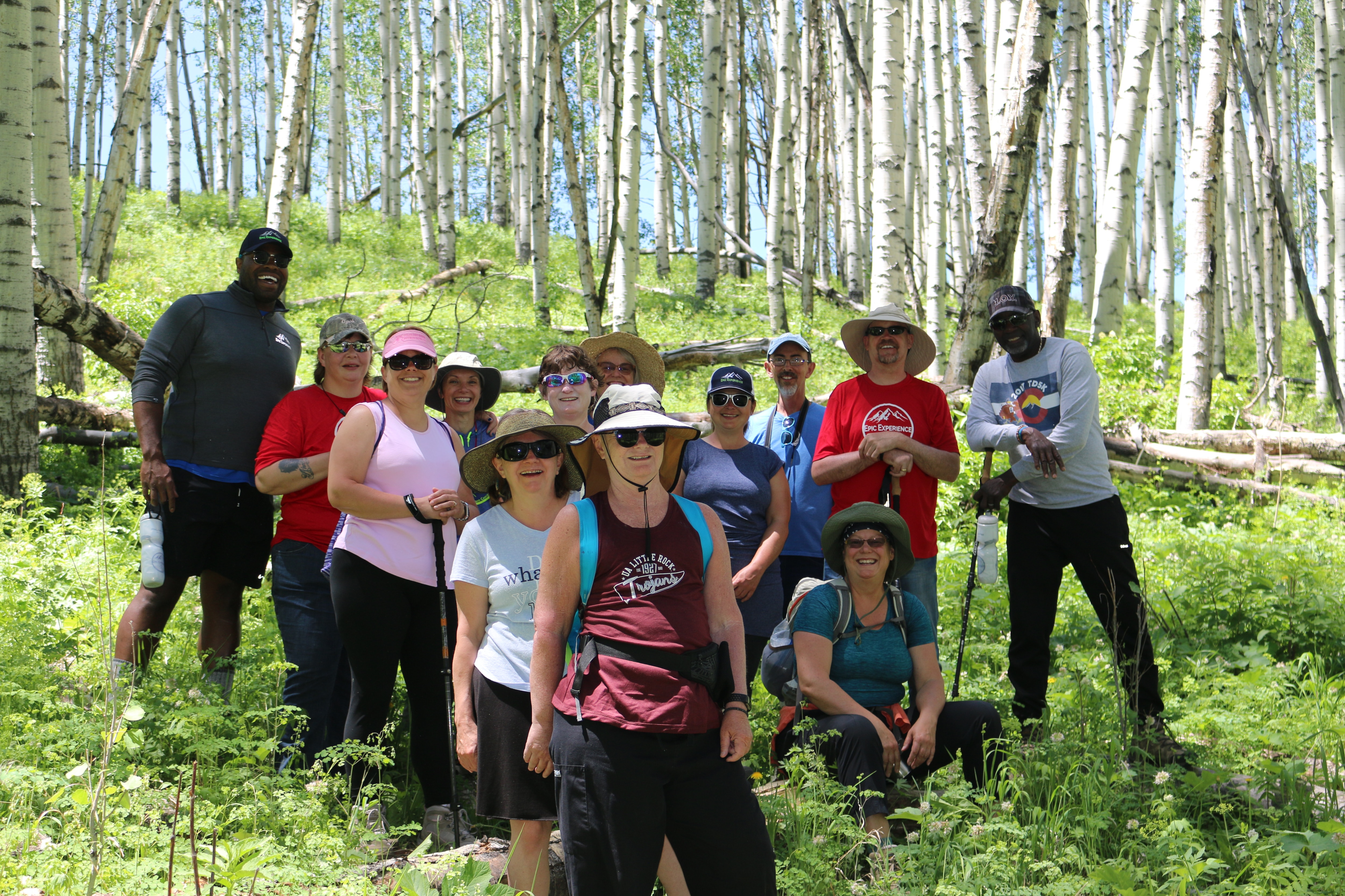group of people standing and smiling in a forest