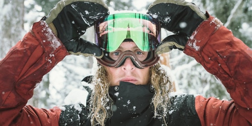 Blonde skier opening the rail lock system on his ski goggles