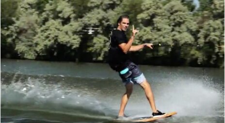 man wakeboarding and holding up the number one