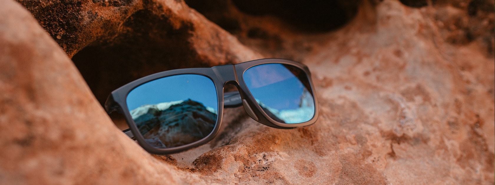 a pair of Zeal Optics sunglasses sitting on sandstone rock