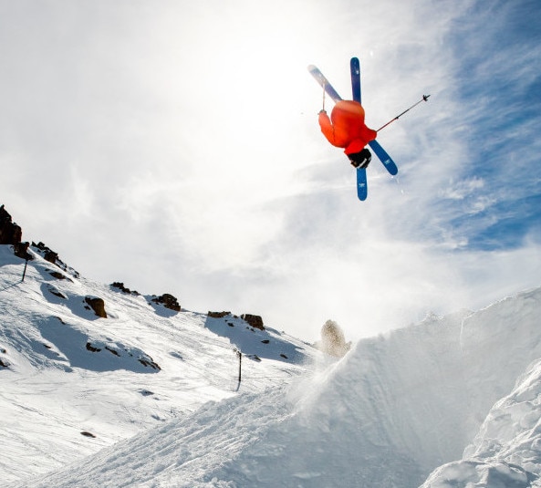 skier flipping through the air in the snow