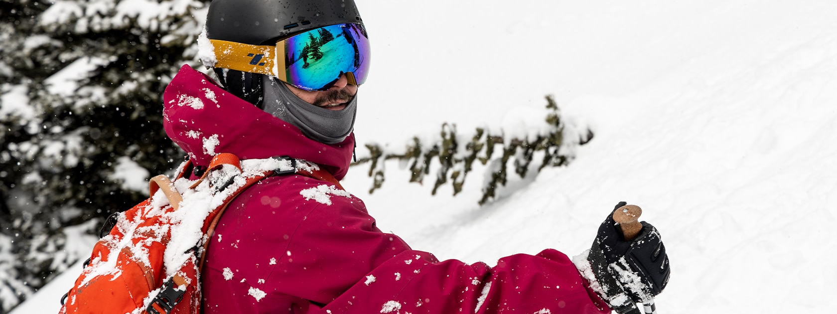 close image of man covered in snow wearing zeal ski and snowboard goggles