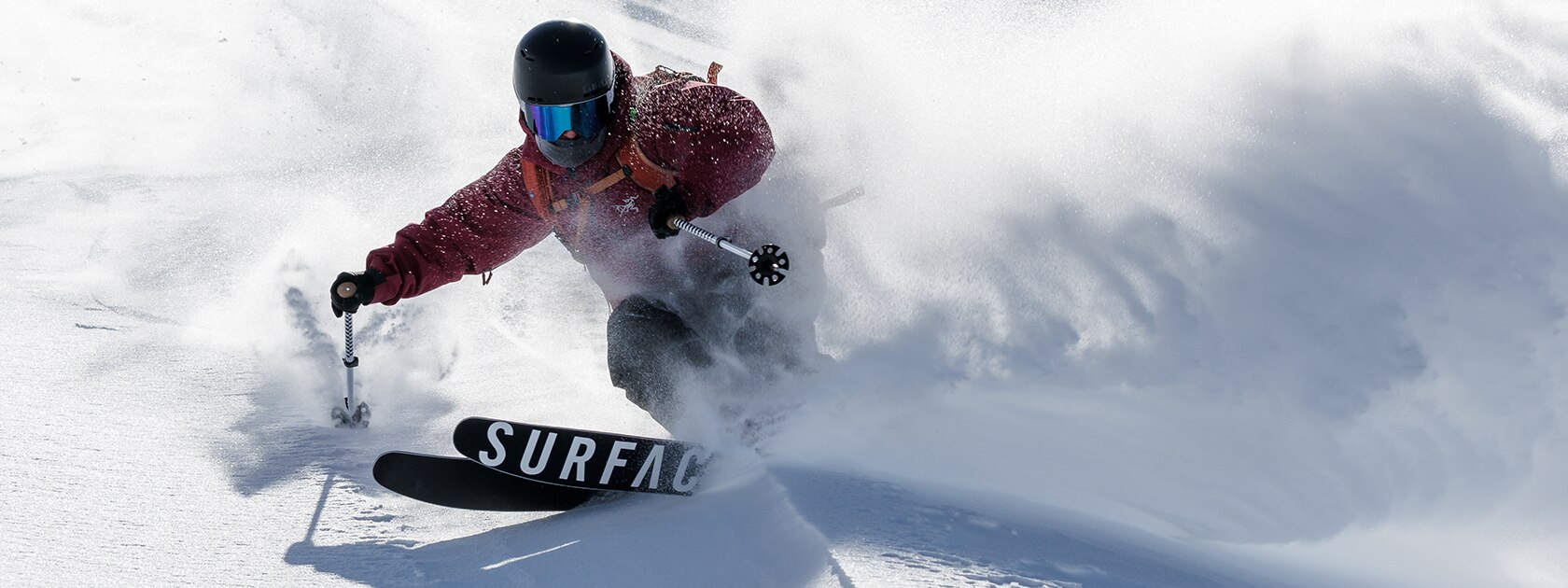 image of a skier wearing zeal ski goggles turning sharply in powder