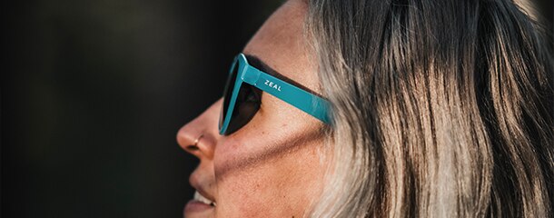 lady with blonde hair wearing teal Zeal sunglasses